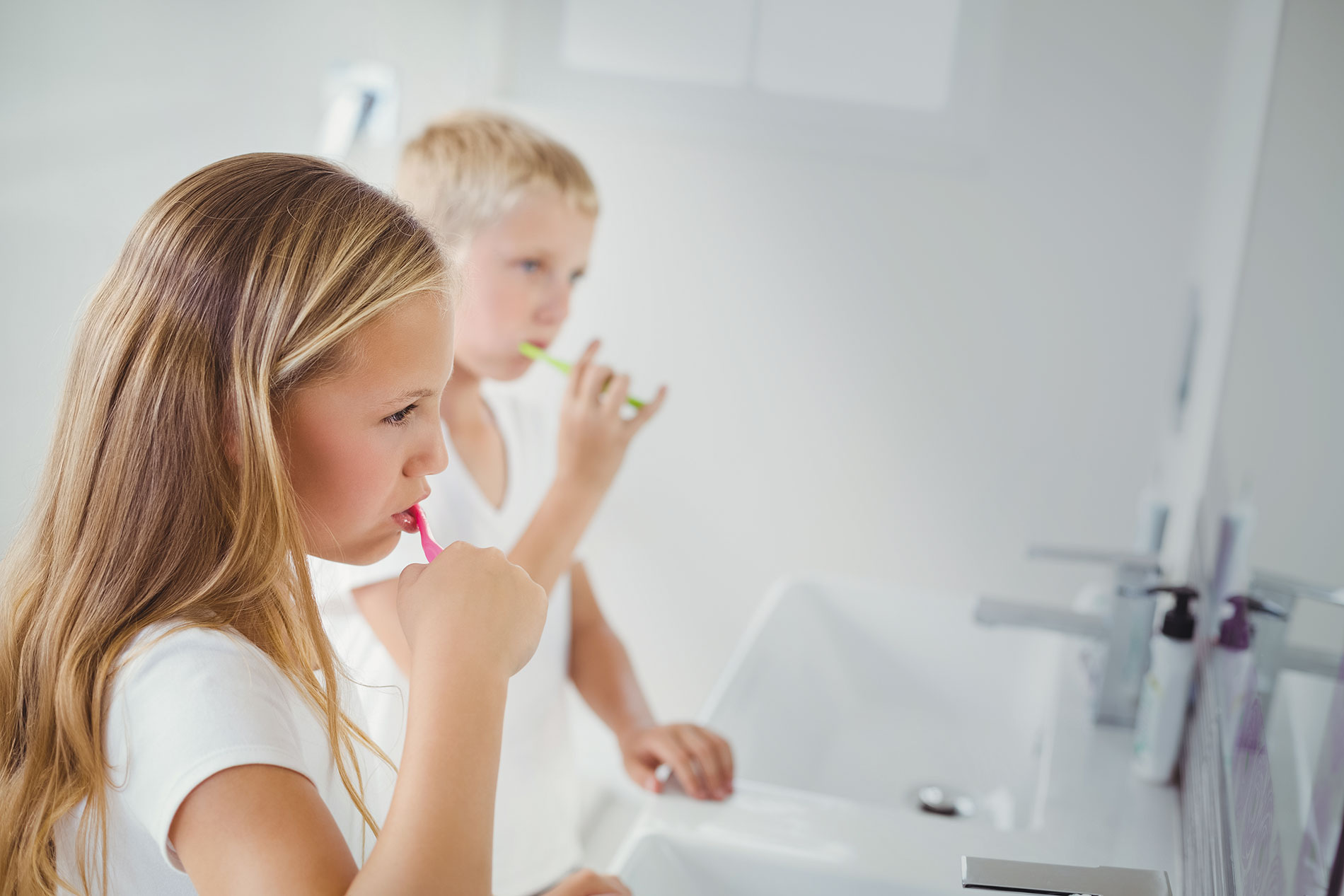 two children brushing their teeth