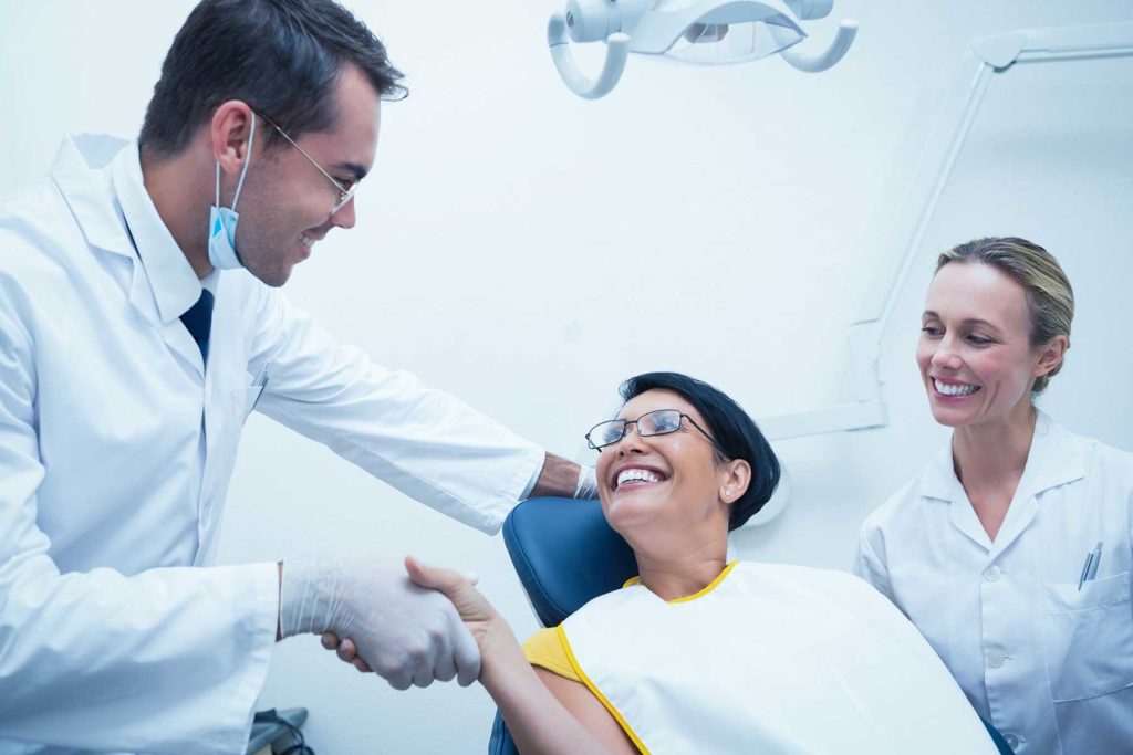 woman greeting her dentist as she prepare for her tooth extractions procedure