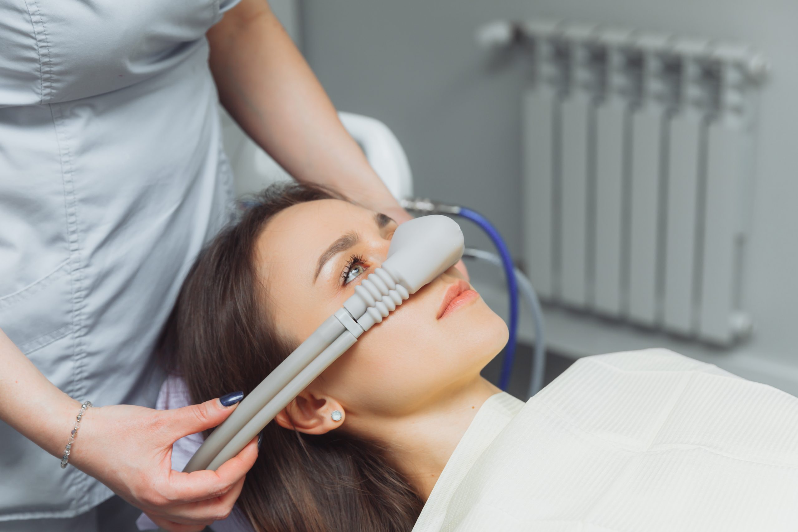 dentist puts nitrous oxide inhalation mask on patient